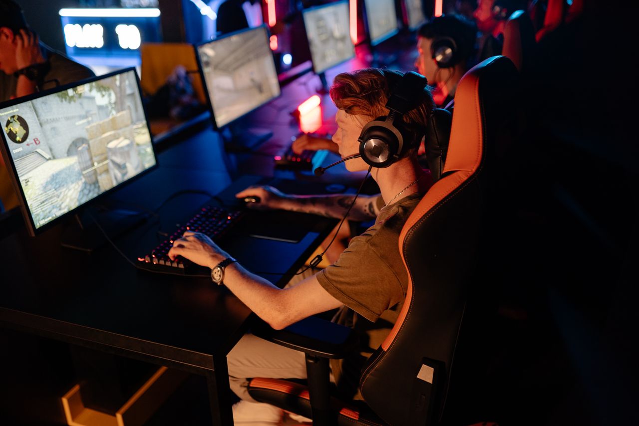 About A group of gamers focused on a competitive match in a dimly lit esports arena.