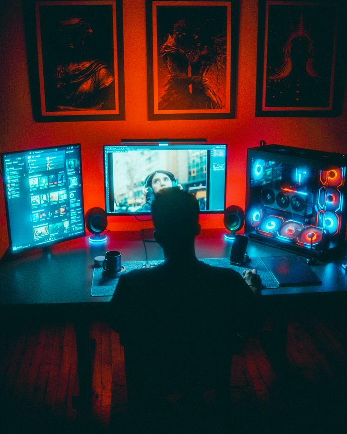 The Art of Drawing Readers In: Your attractive post title goes here A gamer engrossed in a vibrant RGB computer setup with dual monitors at night.